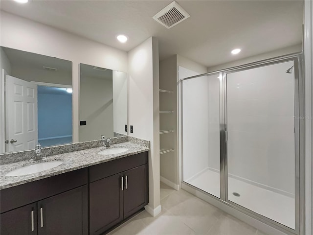 full bathroom with a sink, visible vents, a stall shower, and double vanity