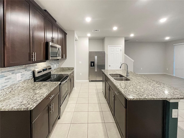 kitchen featuring visible vents, a sink, tasteful backsplash, dark brown cabinetry, and appliances with stainless steel finishes