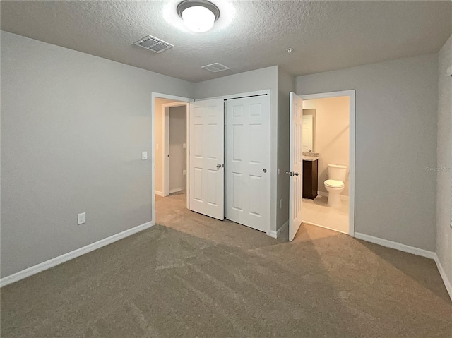 unfurnished bedroom featuring carpet, baseboards, visible vents, a closet, and a textured ceiling