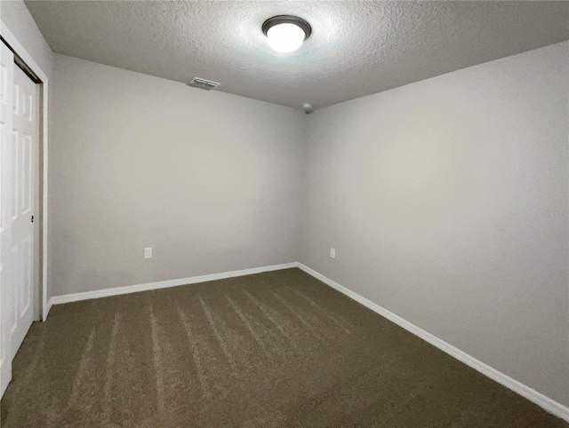 unfurnished bedroom with visible vents, baseboards, dark carpet, a closet, and a textured ceiling