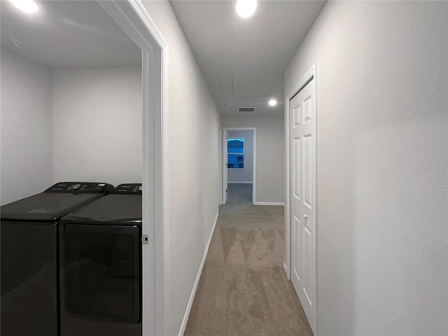 corridor with visible vents, baseboards, washing machine and dryer, and carpet flooring