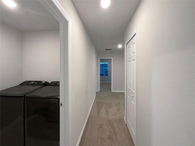 corridor featuring visible vents, carpet, baseboards, and washing machine and clothes dryer