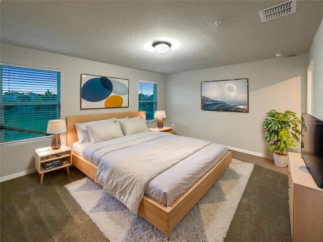 bedroom with visible vents, a textured ceiling, baseboards, and carpet floors