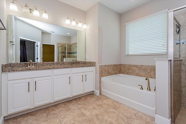 bathroom featuring a spacious closet, double vanity, a stall shower, a bath, and a sink