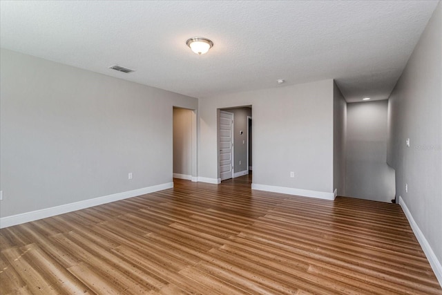 unfurnished room with baseboards, visible vents, and light wood finished floors