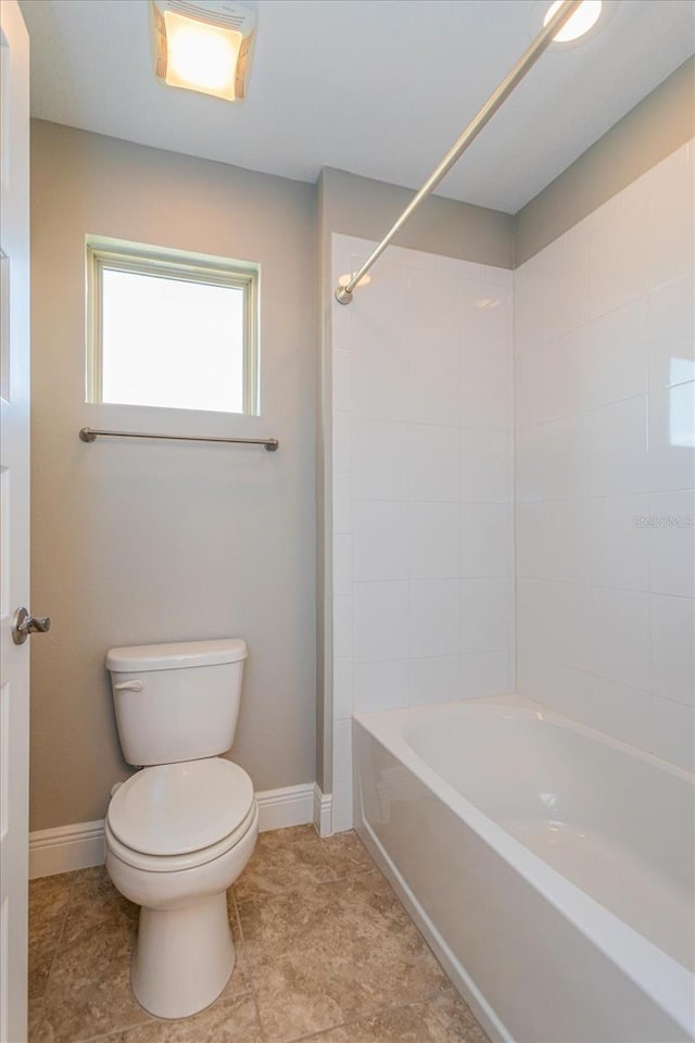 full bath with  shower combination, toilet, and baseboards