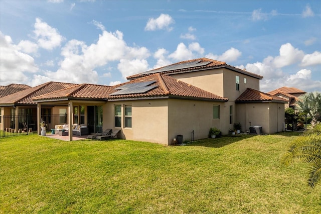 back of property featuring solar panels, an outdoor living space, a patio area, and a lawn