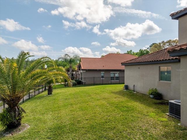 view of yard with central AC unit and fence