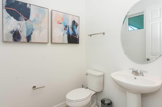 bathroom with toilet and baseboards