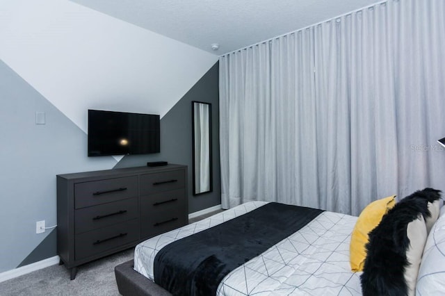 carpeted bedroom with lofted ceiling and baseboards