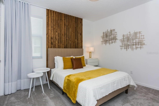 bedroom with baseboards, carpet, and wood walls