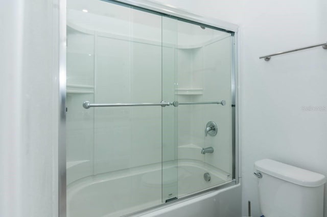 full bathroom with enclosed tub / shower combo and toilet