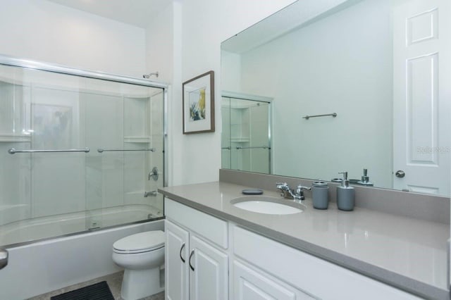 full bathroom with combined bath / shower with glass door, toilet, and vanity