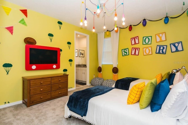 bedroom with carpet, baseboards, ensuite bathroom, and a sink