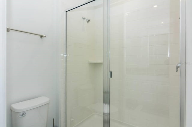 full bathroom with a shower stall and toilet