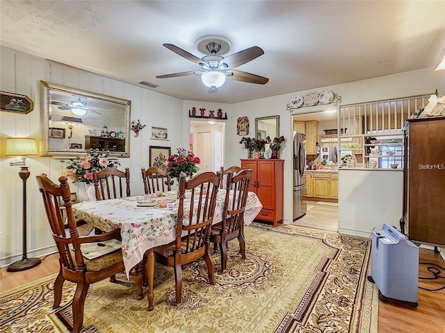 dining room featuring ceiling fan, visible vents, and light wood-style flooring