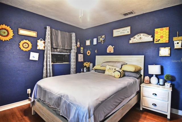 bedroom featuring baseboards, visible vents, and dark wood-style flooring