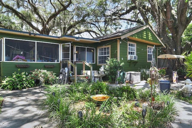 view of front of home with cooling unit and a sunroom