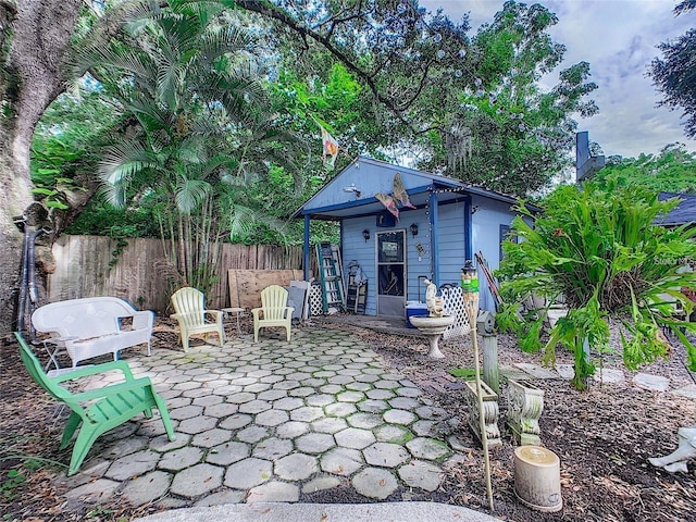 view of patio / terrace with an outbuilding and fence