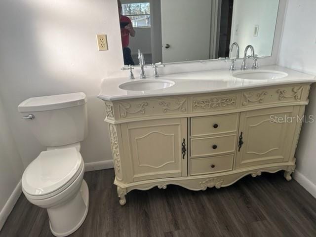 bathroom with wood finished floors, toilet, and a sink