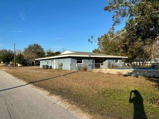 view of front of house with central AC unit and fence