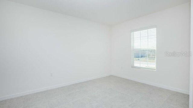 unfurnished room with baseboards