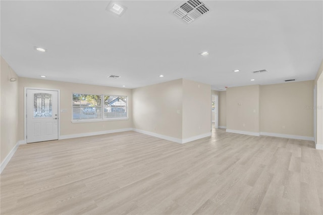 unfurnished living room with baseboards, visible vents, and light wood-type flooring