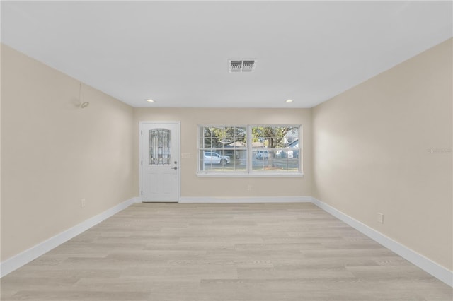 spare room featuring light wood-type flooring, visible vents, baseboards, and recessed lighting