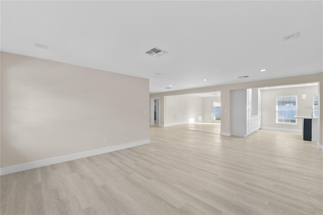 interior space featuring light wood-style flooring, recessed lighting, baseboards, and visible vents