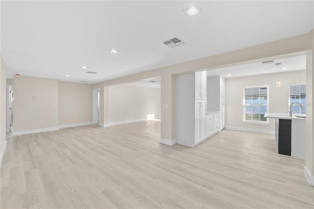 empty room with light wood-style flooring, recessed lighting, baseboards, and visible vents