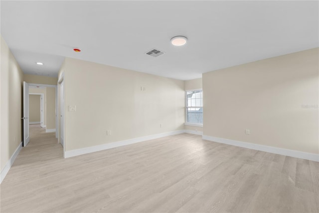 unfurnished room featuring visible vents, baseboards, and light wood-style floors