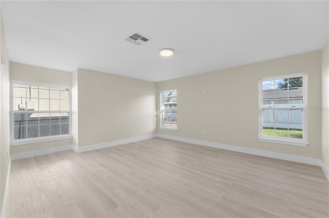 spare room featuring visible vents, baseboards, and light wood-style floors