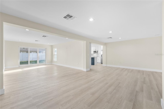 unfurnished living room with recessed lighting, visible vents, baseboards, and light wood-style flooring