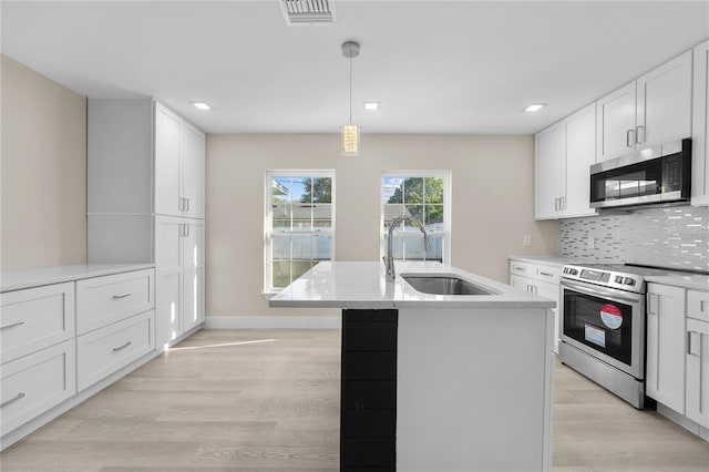 2418 Whitehall Cir, Winter Park, FL 32792 - kitchen with visible vents, light wood-style flooring, appliances with stainless steel finishes, a sink, and backsplash