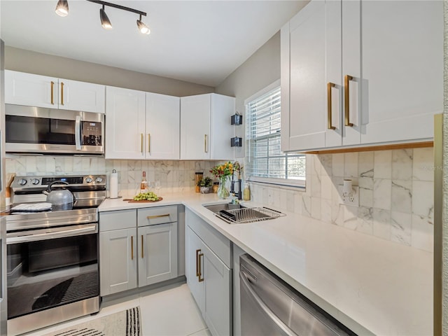 1174 Villa Ln Unit 115, Apopka, FL 32712 - kitchen with appliances with stainless steel finishes, light countertops, tasteful backsplash, and white cabinets