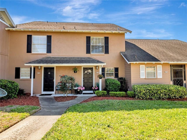 1174 Villa Ln Unit 115, Apopka, FL 32712 - traditional-style home with roof with shingles, a front lawn, and stucco siding