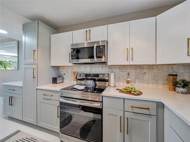 1174 Villa Ln Unit 115, Apopka, FL 32712 - kitchen featuring stainless steel appliances, light countertops, light tile patterned flooring, and decorative backsplash