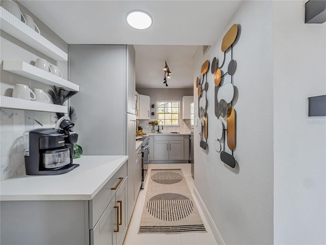 1174 Villa Ln Unit 115, Apopka, FL 32712 - kitchen with gray cabinets, light tile patterned floors, open shelves, decorative backsplash, and stainless steel electric stove