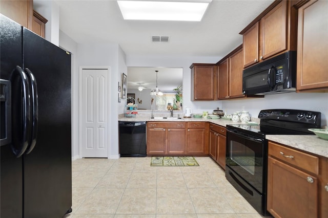 3823 Ryegrass St, Clermont, FL 34714 - kitchen featuring visible vents, brown cabinetry, light countertops, a sink, and black appliances