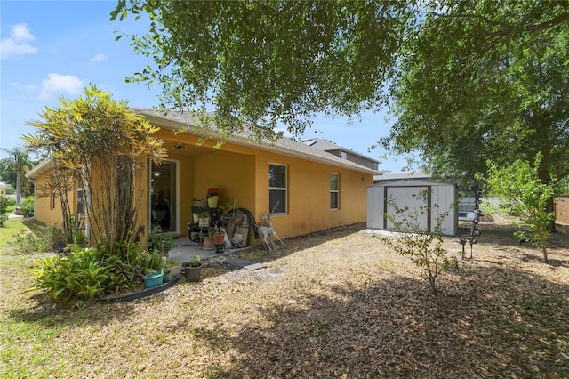 3823 Ryegrass St, Clermont, FL 34714 - back of property featuring a storage unit, an outdoor structure, and stucco siding