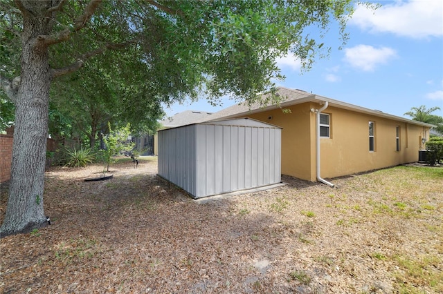 3823 Ryegrass St, Clermont, FL 34714 - view of property exterior featuring a storage shed, cooling unit, an outbuilding, and stucco siding