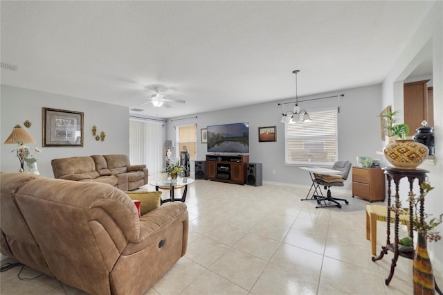 3823 Ryegrass St, Clermont, FL 34714 - living area featuring light tile patterned floors, baseboards, ceiling fan with notable chandelier, and visible vents