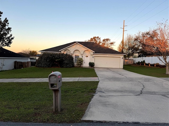 ranch-style house featuring fence, concrete driveway, a lawn, stucco siding, and a garage