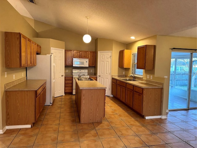 kitchen featuring a center island with sink, lofted ceiling, brown cabinets, white appliances, and a sink