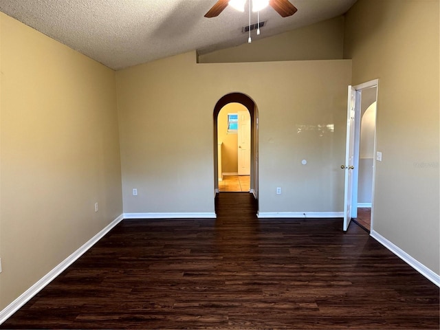 unfurnished room featuring arched walkways, dark wood-type flooring, a ceiling fan, and vaulted ceiling