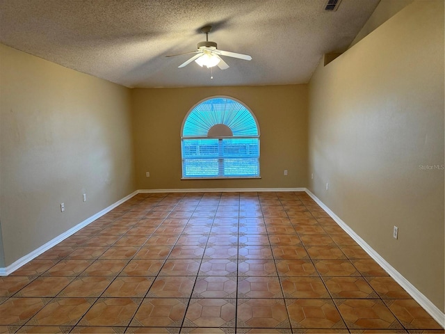 spare room featuring light tile patterned floors, a ceiling fan, baseboards, and a textured ceiling