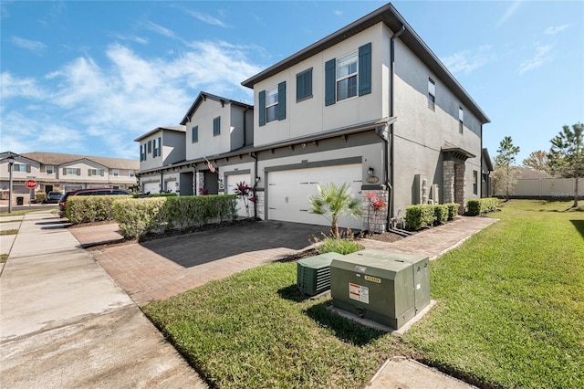 view of front of home with stucco siding, decorative driveway, a residential view, a front yard, and a garage