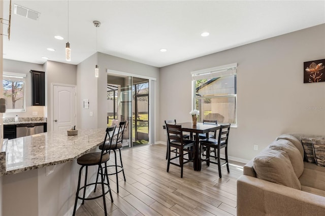 dining room with a wealth of natural light, visible vents, baseboards, and light wood-style floors