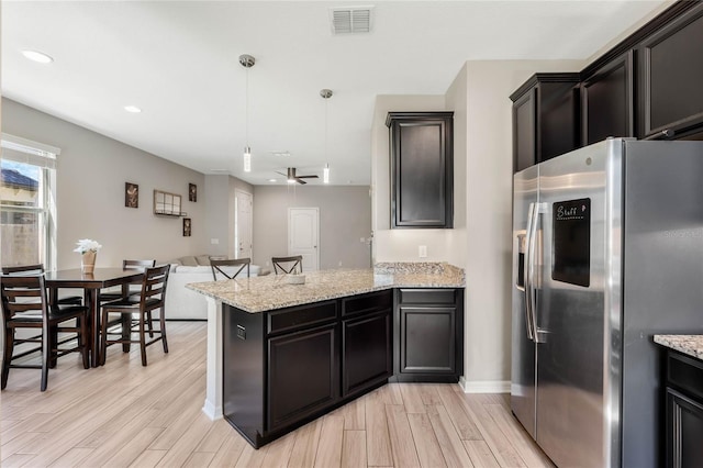 kitchen featuring visible vents, wood finish floors, open floor plan, a peninsula, and stainless steel refrigerator with ice dispenser