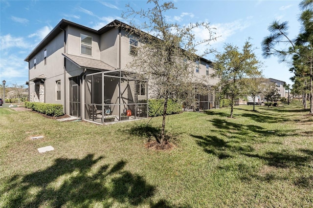 rear view of property with a lanai, stucco siding, and a yard